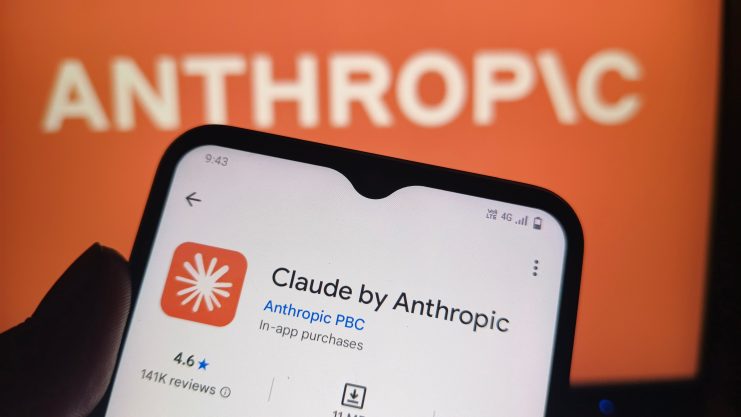 Handy-Bildschirm mit Claude App vor Hintergrund auf dem "Anthropic" steht