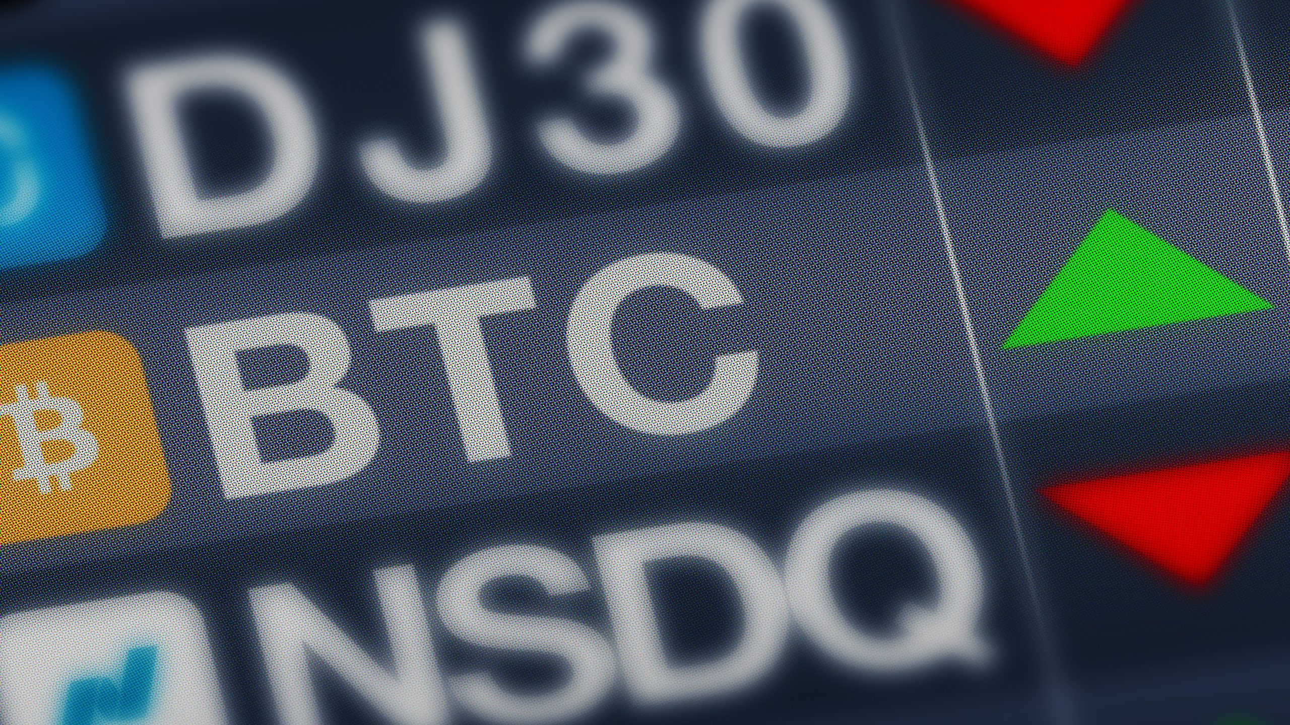 Zu sehen sind Tickersymbole bon Bitcoin und Nasdaq