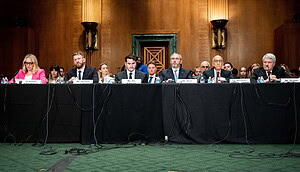 Verschiedene Personen sitzen an erinem Tisch