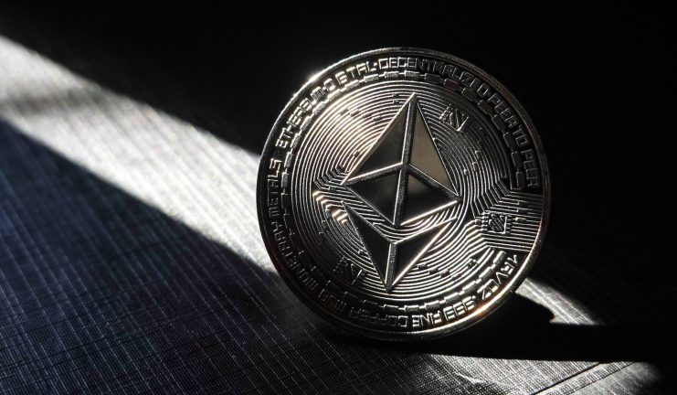Eine Ethereum-Münze vor dunklem Hintergrund.