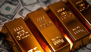 Goldbarren liegen auf Dollarscheinen