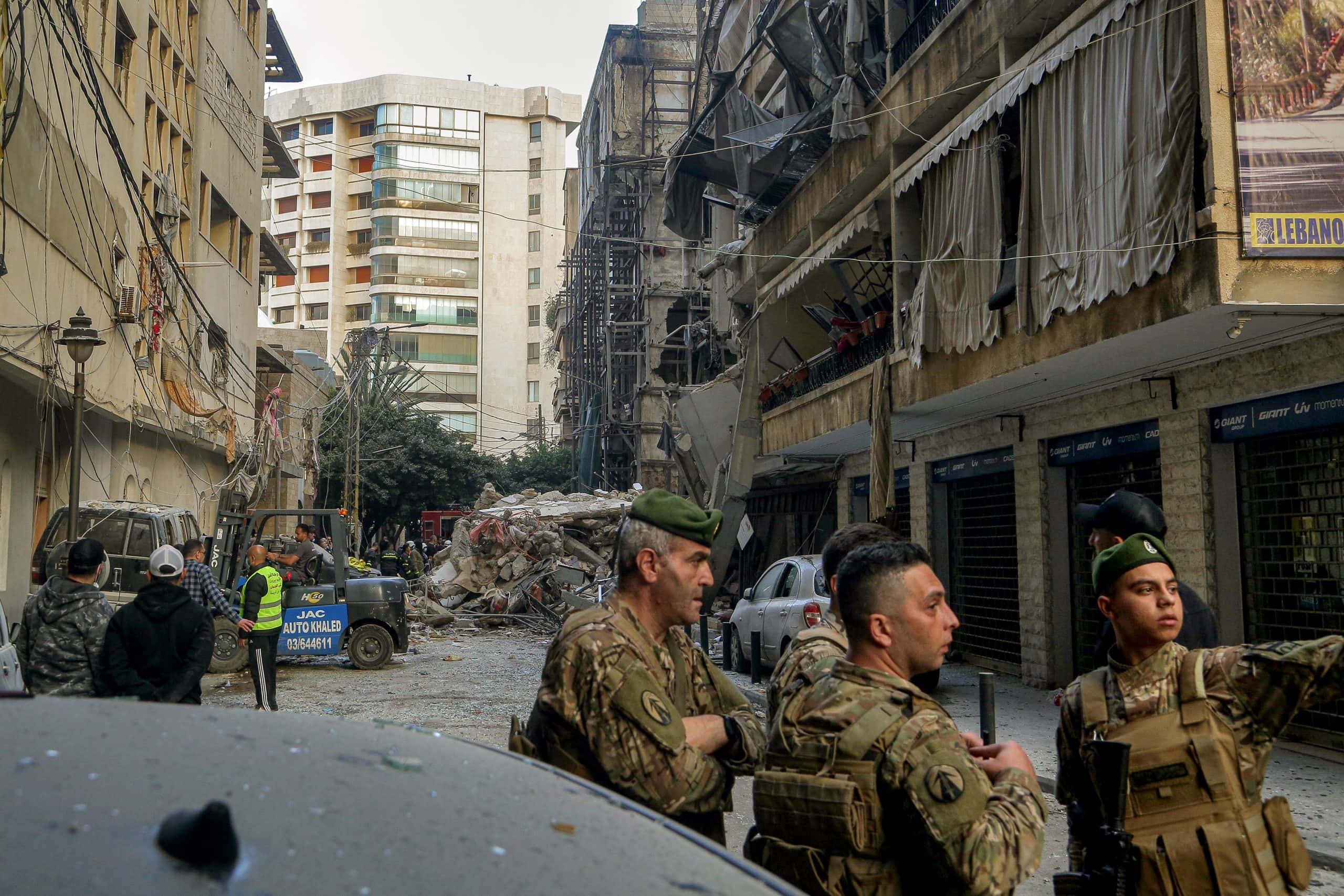 Mitarbeiter des Zivilschutzes versammeln sich in der Nähe der Trümmer eines Gebäudes, das bei einem israelischen Luftangriff in der Nähe der Beiruter Küste zerstört wurde