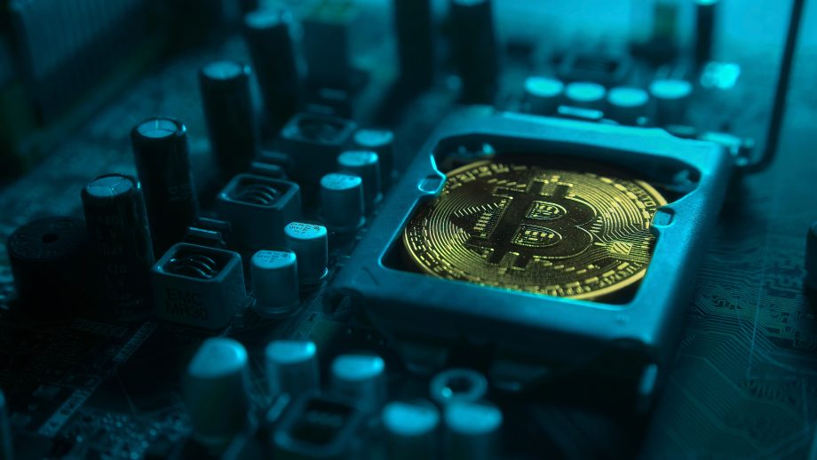 Eine Bitcoin-Münze liegt auf einem Schaltkreis einer Festplatte.