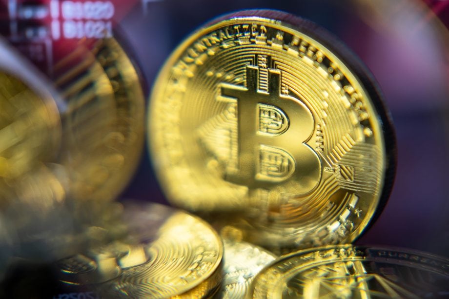 Eine Bitcoin-Münze wird leicht verschwommen angezeigt. Neben ihr sind andere unscharfe Bitcoin-Münzen dargestellt.