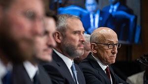 Ripple CEO Brad Garlinghouse သည် အခြားသူများနှင့် စားပွဲတစ်ခုတွင် ထိုင်သည်။