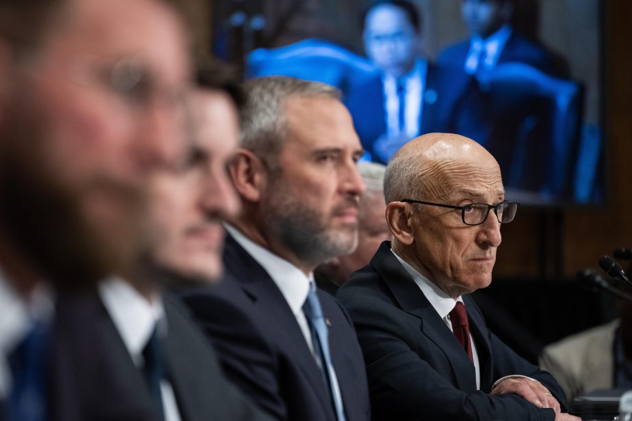 Ripple-CEO Brad Garlinghouse sitzt an einem Tisch mit anderen Personen