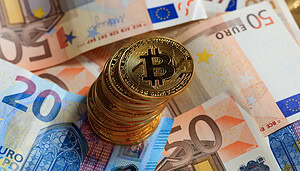Das Bild zeigt Bitcoin-Münzen und Euro-Scheine, die symbolisch für einen Euro-Stablecoin stehen.