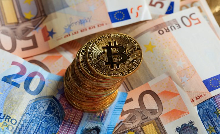 Das Bild zeigt Bitcoin-Münzen und Euro-Scheine, die symbolisch für einen Euro-Stablecoin stehen.