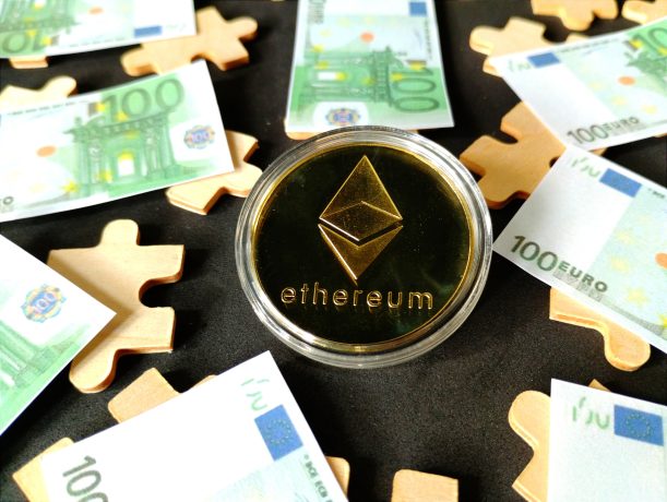 Das Bild zeigt eine Ethereum-Münze, um die mehrere 100-Euro-Noten liegen.