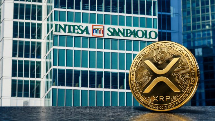 Eine XRP-Münze neben einem Bürogebäude der Intesa Sanpaolo.