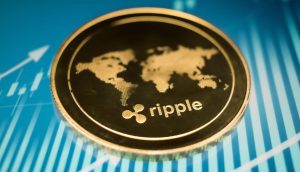 Eine Nahaufnahme einer goldenen Ripple (XRP)-Kryptowährungsmünze mit einem Weltkartenmotiv auf blauem Hintergrund mit Finanzdiagrammlinien.