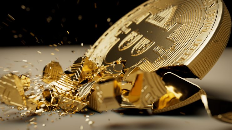 Eine zerbrochene Bitcoin-Münze liegt auf dem Boden