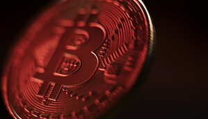 Eine rot beleuchtete Bitcoin-Münze
