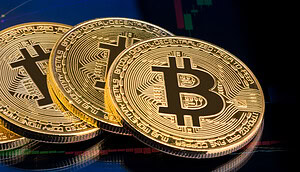 Mehrere goldene Bitcoin-Münzen liegen vor einem Börsenchart mit grünen und roten Kurskerzen. Das Bild symbolisiert die aktuellen Kapitalzuflüsse in Spot-Bitcoin-ETFs und die Entwicklung des Kryptomarkts.
