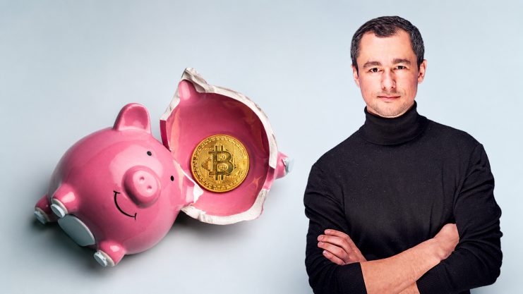 Links erkennt man ein aufgebrochenes Sparschwein mit einer Bitcoin-Münze innenliegend. Rechts daneben ist ein Mann mit schwarzem Rollkragenpullover zu sehen. Beides vor grauem Hintergrund.