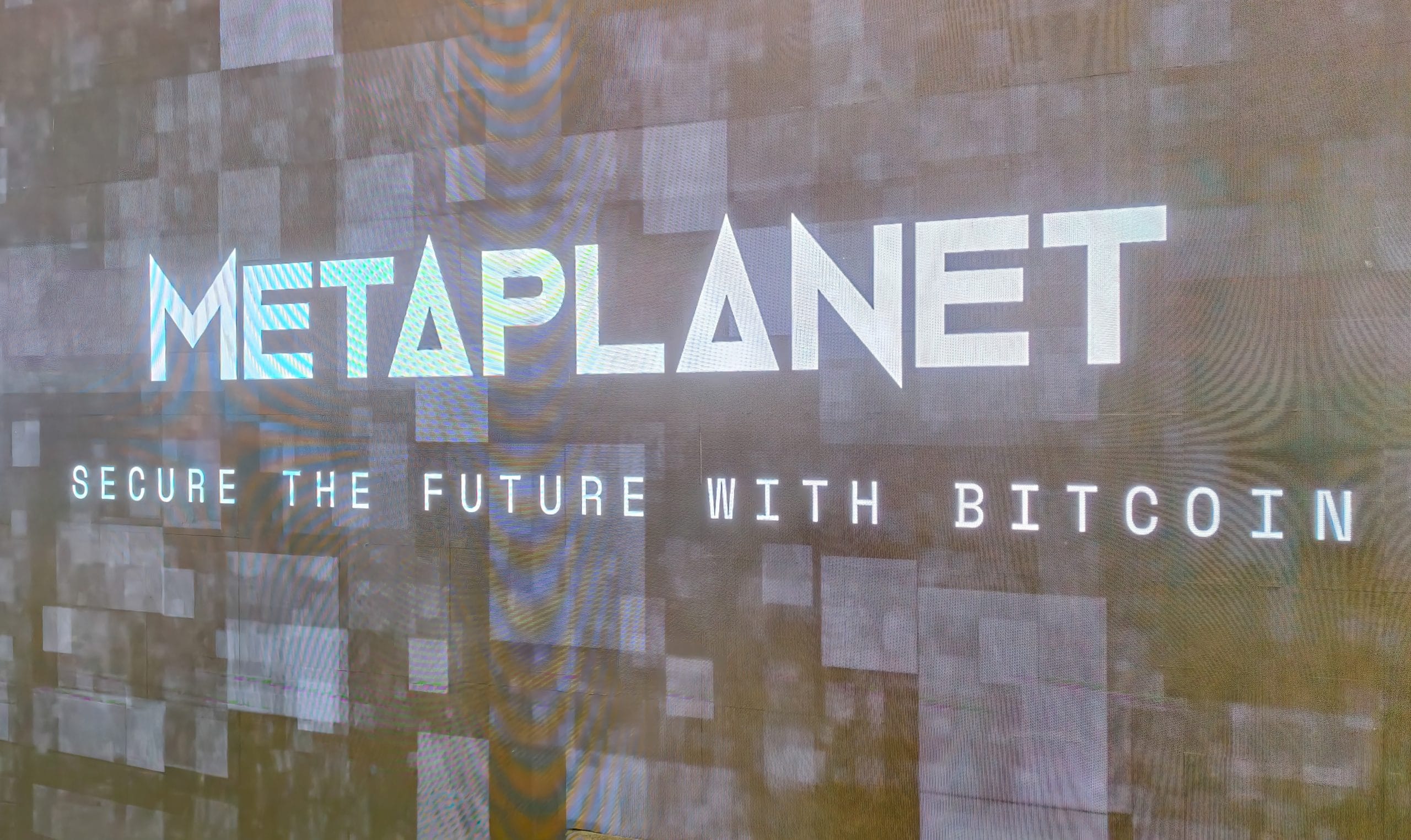 Das Bild zeigt das Logo von Metaplanet mit einer Aufschrift zu Bitcoin.