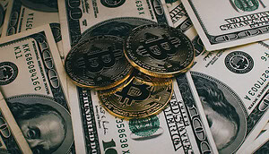 Das Bild zeigt eine Bitcoin-Münze auf Dollar-Scheinen