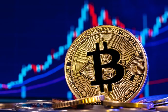Eine Bitcoin-Münze vor einem Chart
