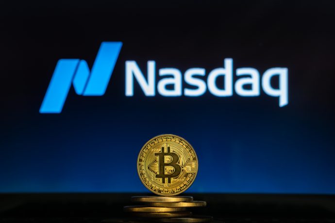 Das Bild zeigt eine Bitcoin-Münze mit dem Nasdaq-Logo