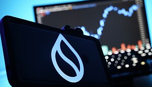 Im Vordergrund ist ein Display mit dem Logo der Sui-Blockchain zu sehen. Im Hintergrund zeigt ein unscharfer Monitor einen Kurschart mit Candlesticks, was den Bezug zum Kryptomarkt verdeutlicht.