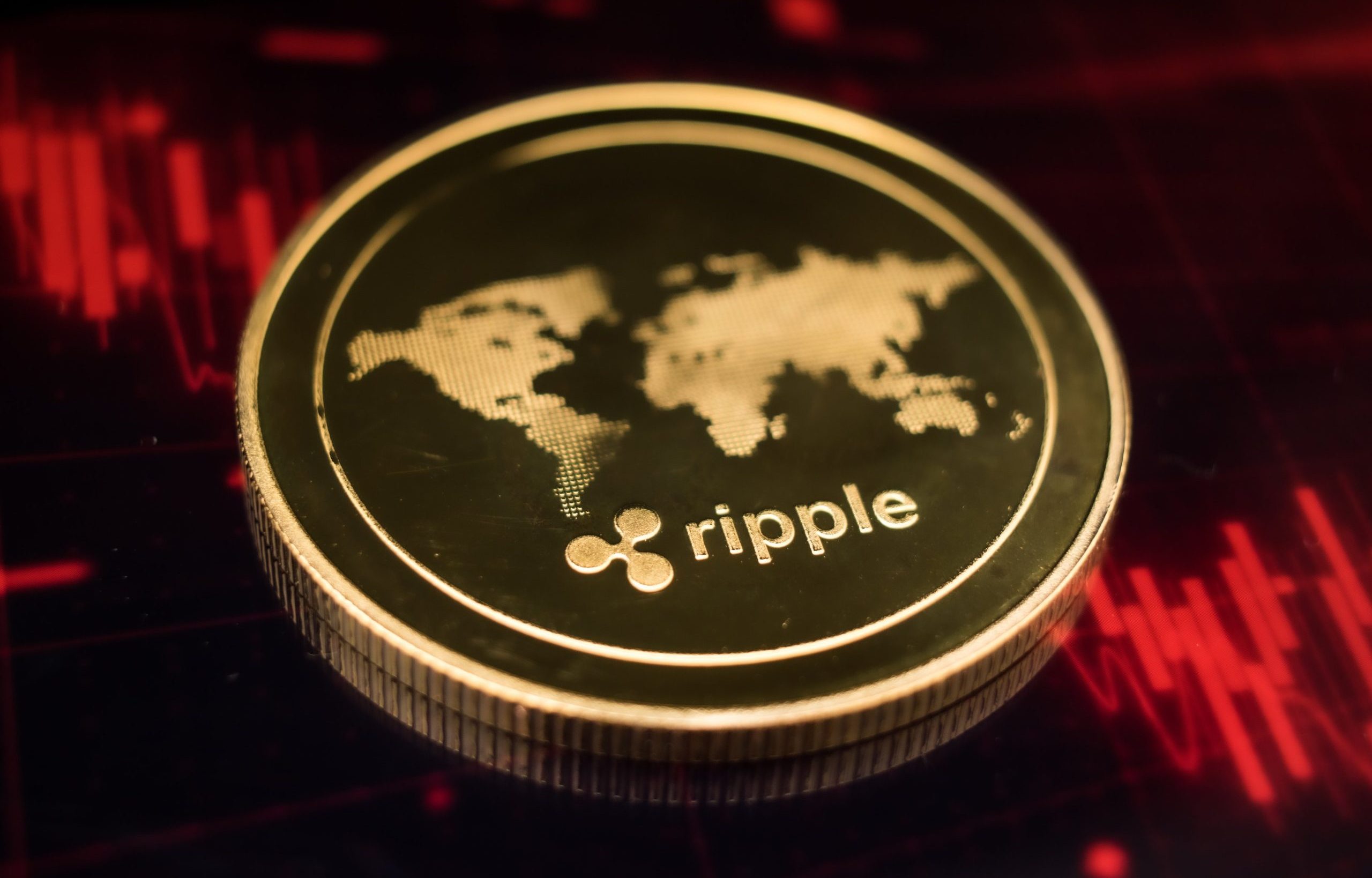 Eine XRP-Münze liegt auf einem roten Kurschart