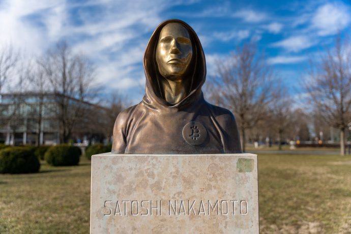 Das Bild zeigt eine Statue von Satoshi Nakamoto