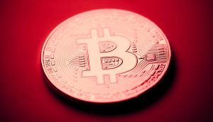 Eine Bitcoin-Münze vor einem roten Hintergrund