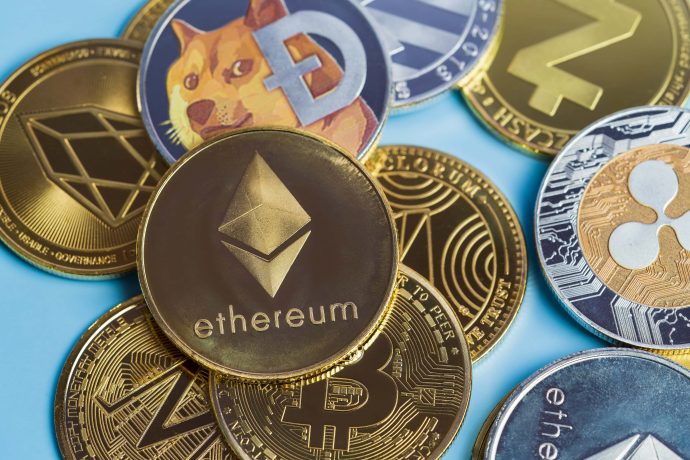Verschiedene physische Münzen mit Logos beliebter Kryptowährungen, darunter Ethereum, Bitcoin und Ripple