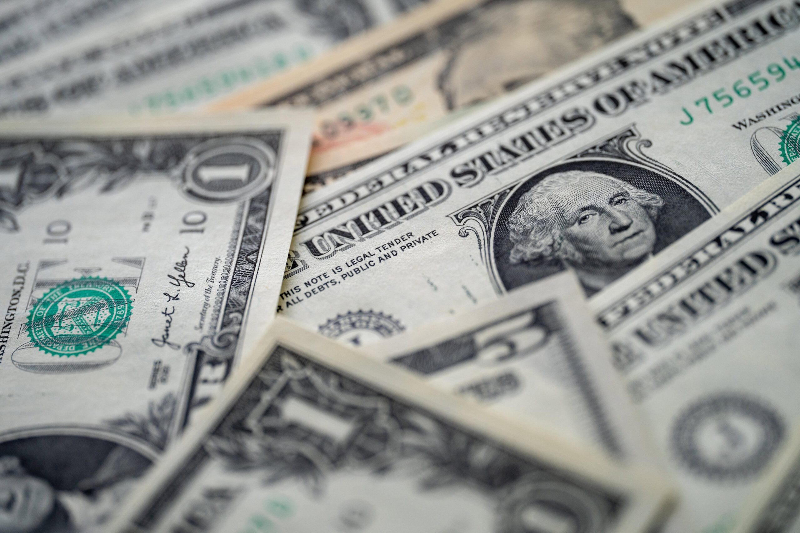 US-Dollar-Banknoten liegen übereinander und symbolisieren die Entwicklung von Inflation, Zinsen und Geldpolitik in den USA.