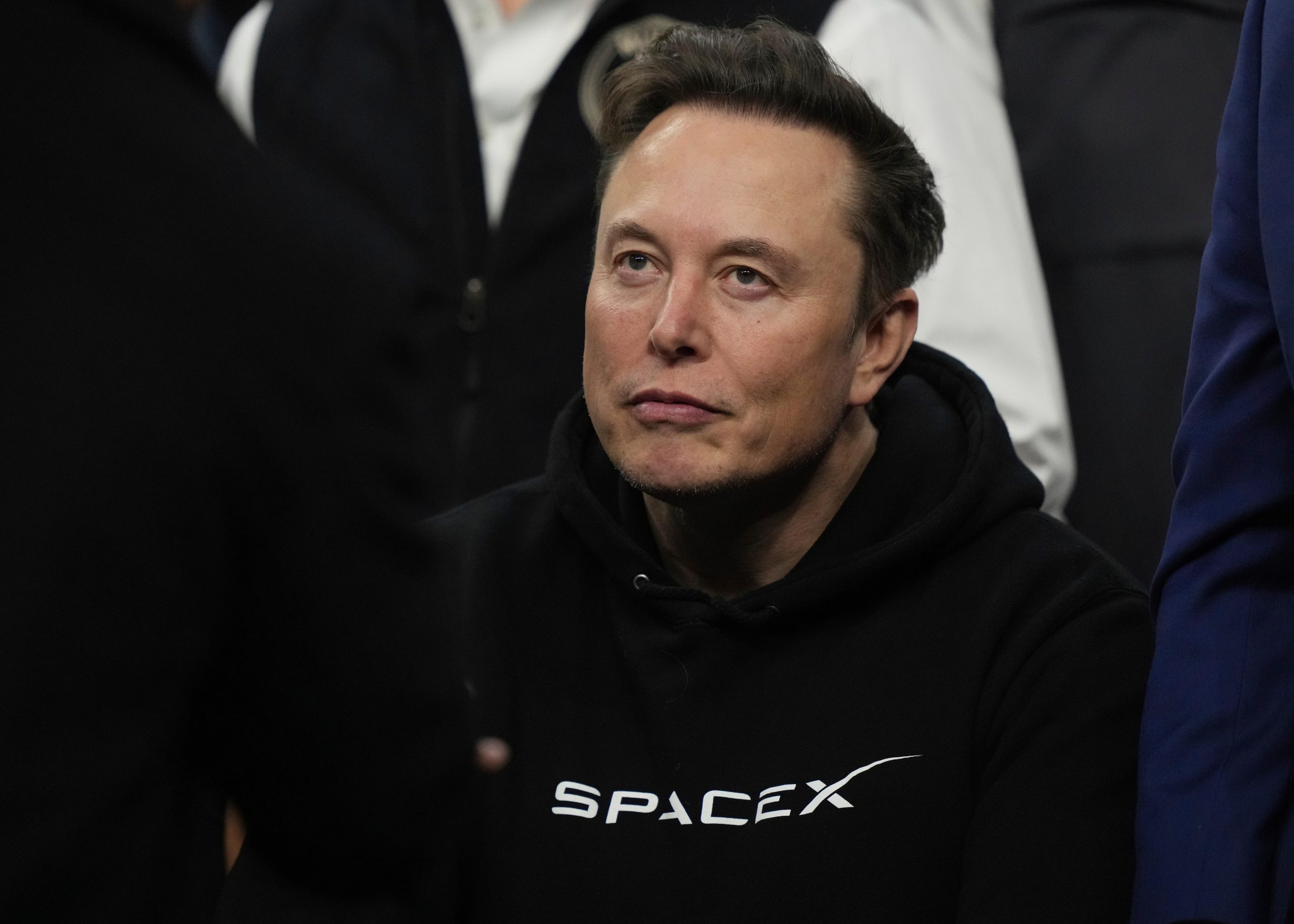 SpaceX-CEO Elon Musk sitzt im schwarzen Pullover des Unternehmens.