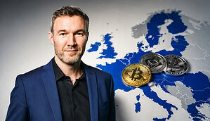OKX Europa-Chef Erald Ghoos vor einer Europa-Karte mit Kryptowährungen
