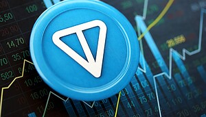 Eine Münze mit Toncoin-Logo liegt auf einem blau gefärbten Kurschart