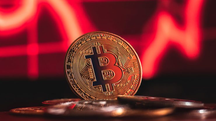 Bitcoin-Münze vor rotem Hintergrund