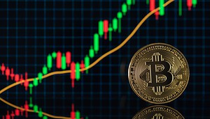 Bitcoin vor einem Kurschart.