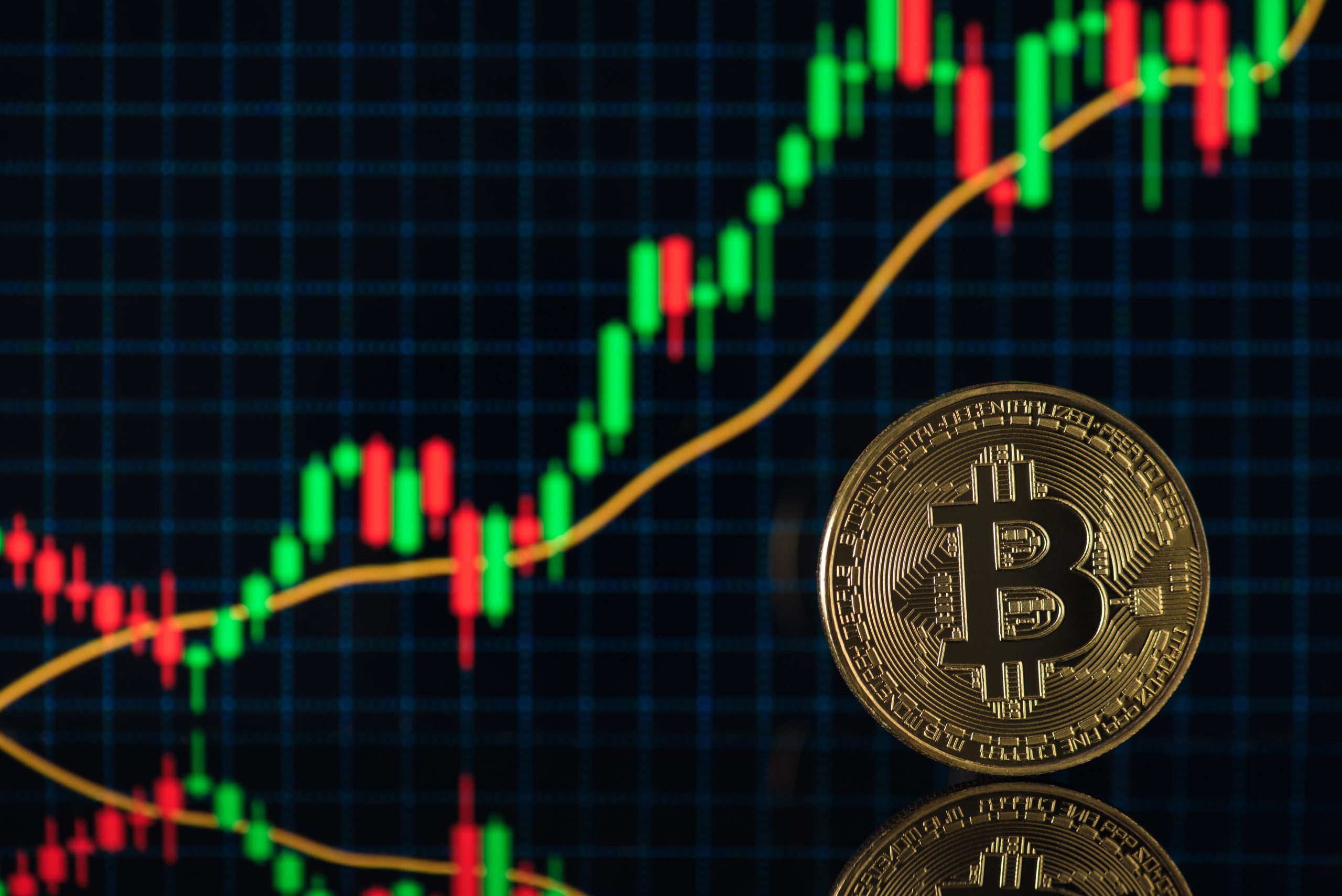Bitcoin vor einem Kurschart.