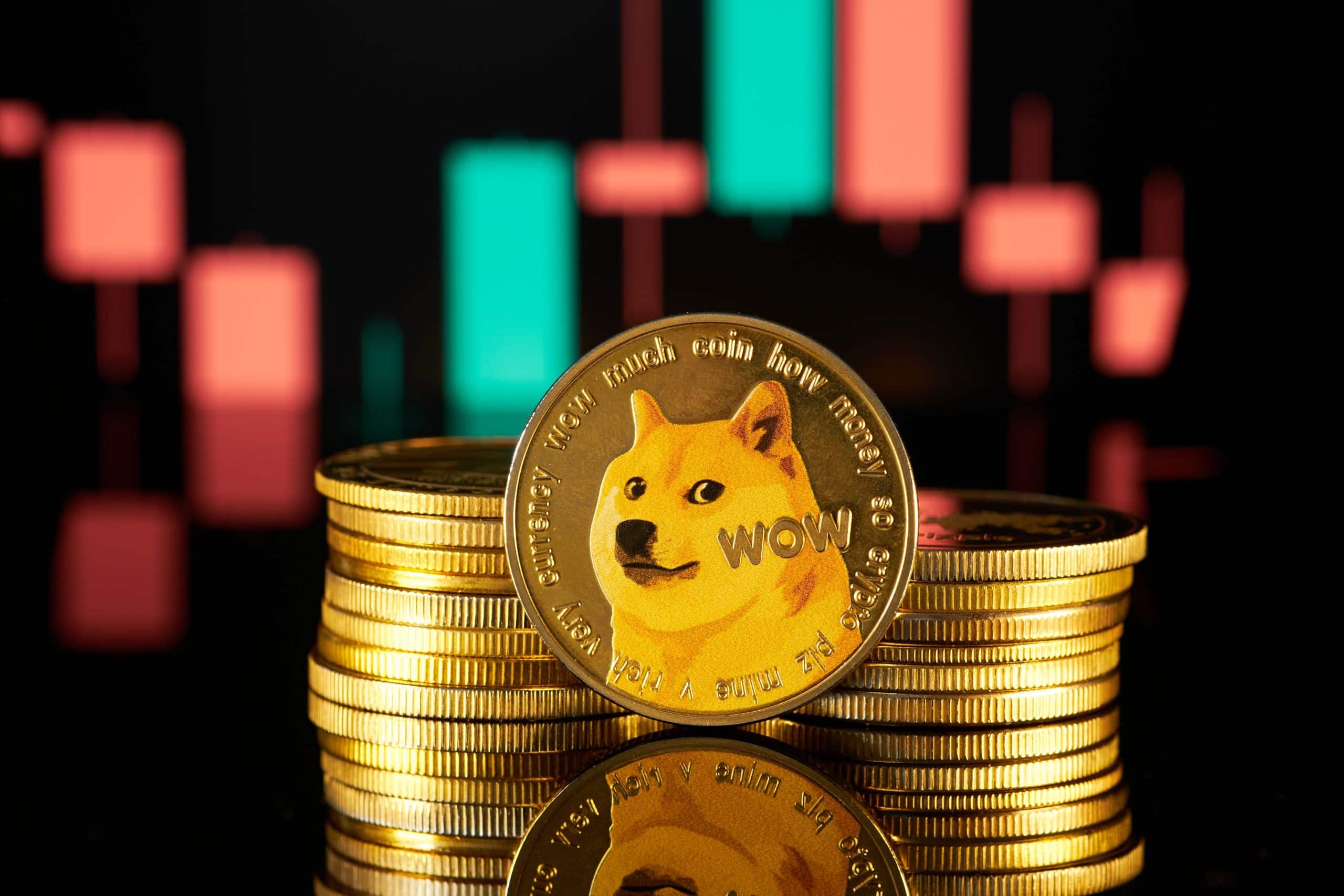 Ein Stapel Dogecoin-Token steht vor einem unscharfen Candlestick-Diagramm.