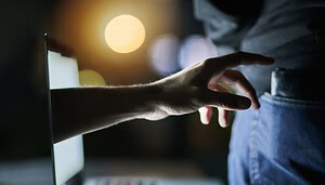 Das Bild zeigt eine Hand, die nach einer Brieftasche greift