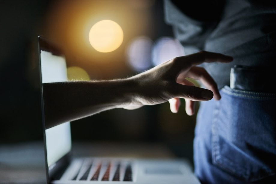 Das Bild zeigt eine Hand, die nach einer Brieftasche greift