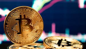 Eine Bitcoin-Münze vor einem Chartbild