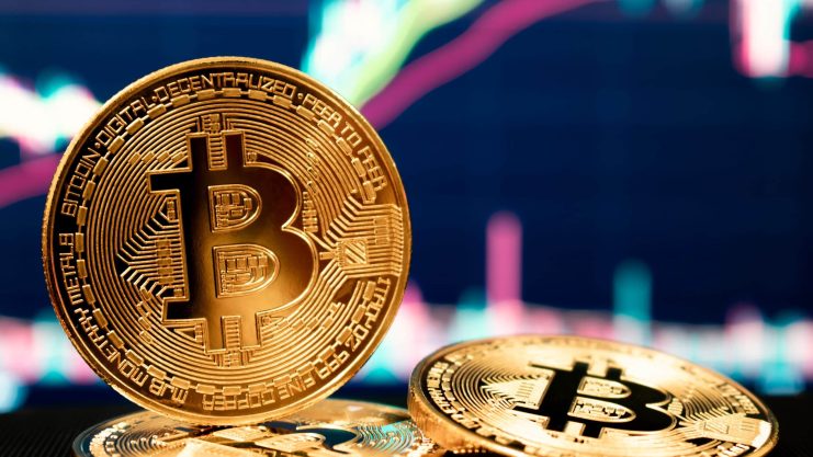 Eine Bitcoin-Münze vor einem Chartbild