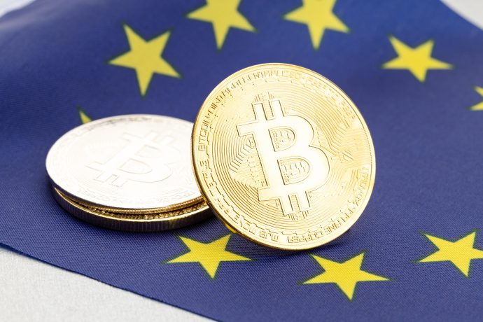 Eine Bitcoin-Münze auf einer Europa-Fahne