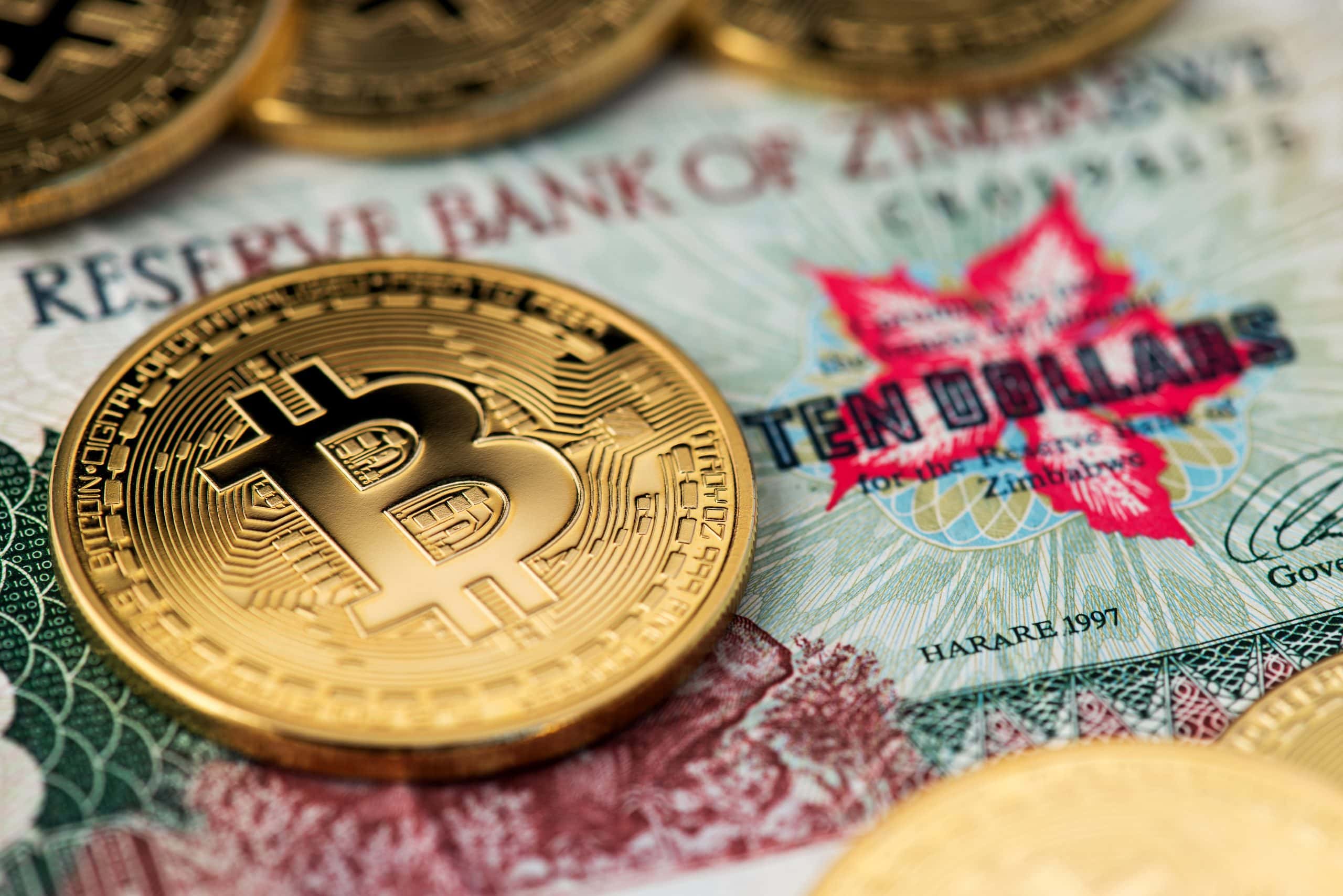 Bitcoin-Münze vor Simbabwe Dollar