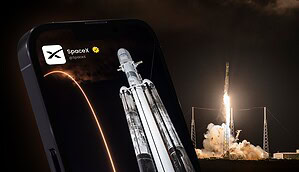 Handy mit SpaceX-Ticker, dahinter Raketenstart