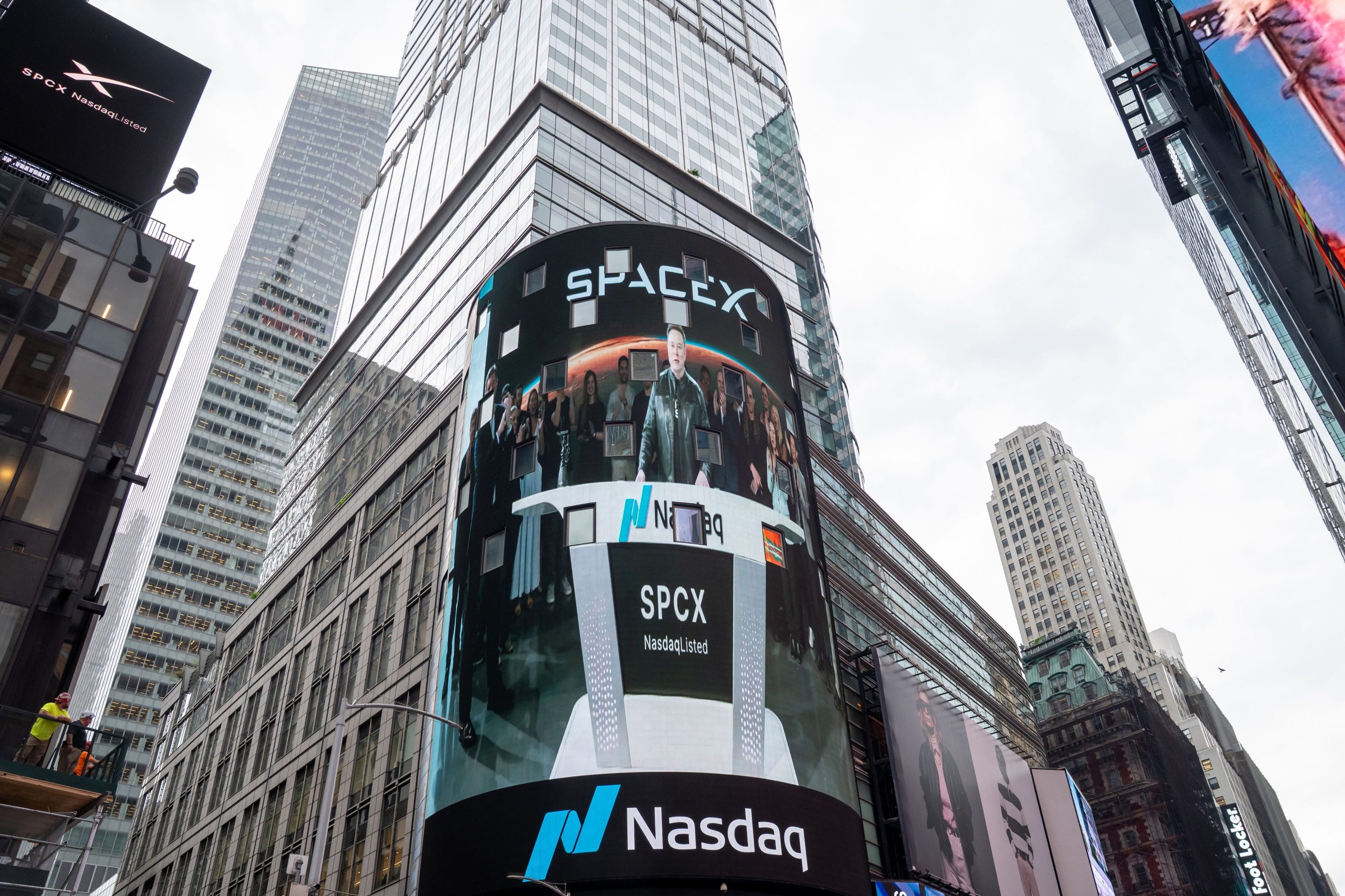 Ein Bildschirm über dem Eingang zur Technologiebörse Nasdaq zeigt Elon Musk und SpaceX-Mitarbeiter beim Börsengang.