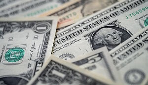 US-Dollar-Banknoten liegen übereinander und symbolisieren die Entwicklung von Inflation, Zinsen und Geldpolitik in den USA.