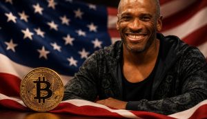 Ein lächelnder Mann steht am rechten Bildrand vor einer US-Flagge. Im Vordergrund liegt eine goldene Bitcoin-Münze auf dem Stoff der amerikanischen Flagge.