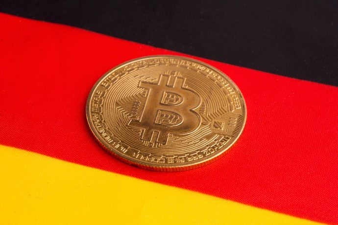 Eine Bitcoin-Münze vor einer Deutschlandflagge