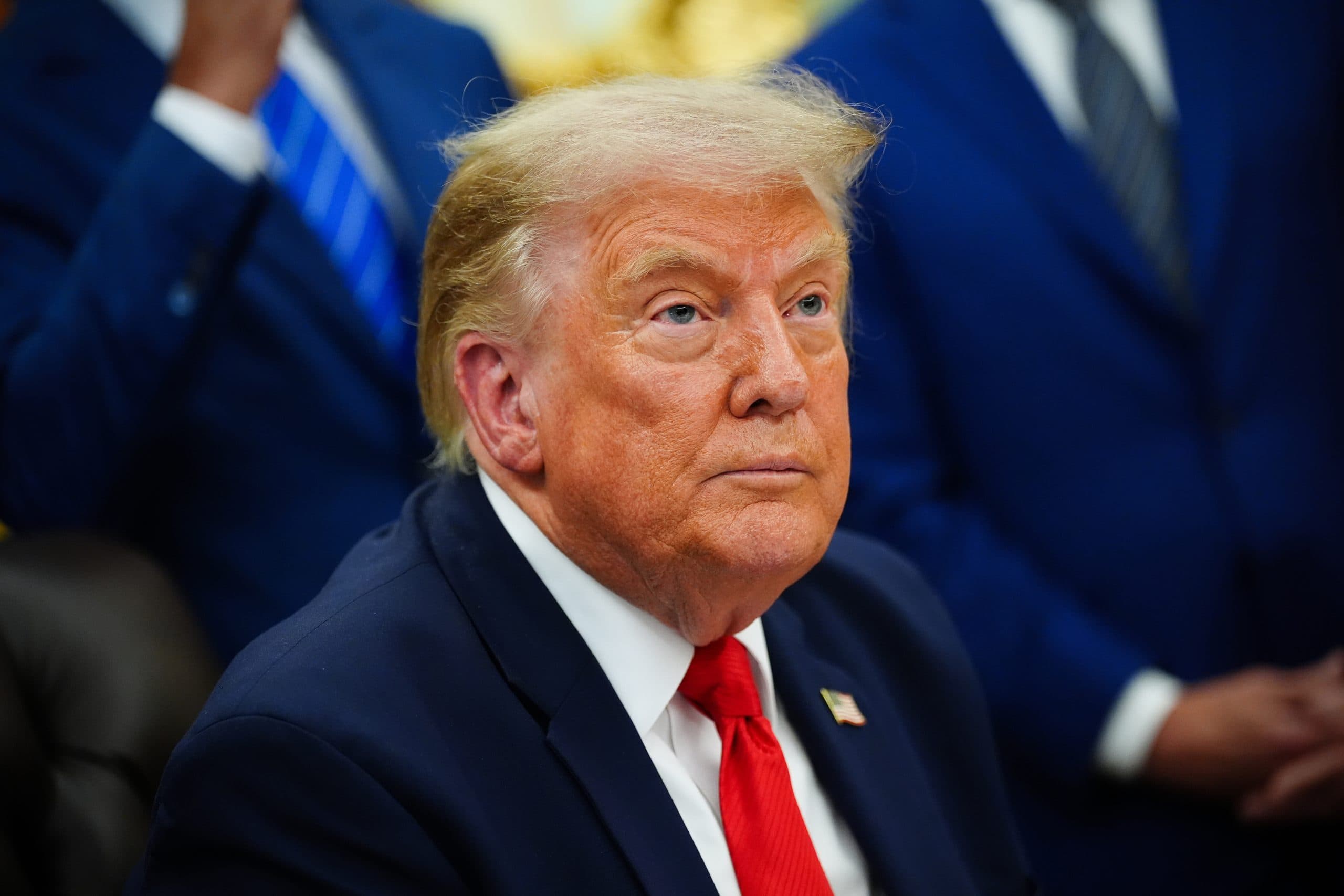 Das Bild zeigt Donald Trump in einem Anzug, wie er nach oben blickt.
