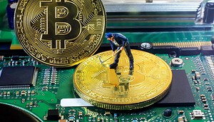 Eine kleine Figur eines Arbeiters steht auf einer großen Bitcoin-Münze auf einem Computer-Motherboard, ein weiterer Bitcoin steht aufrecht neben ihm und symbolisiert die Arbeit, die hinter dem Mining von Kryptowährungen steckt.