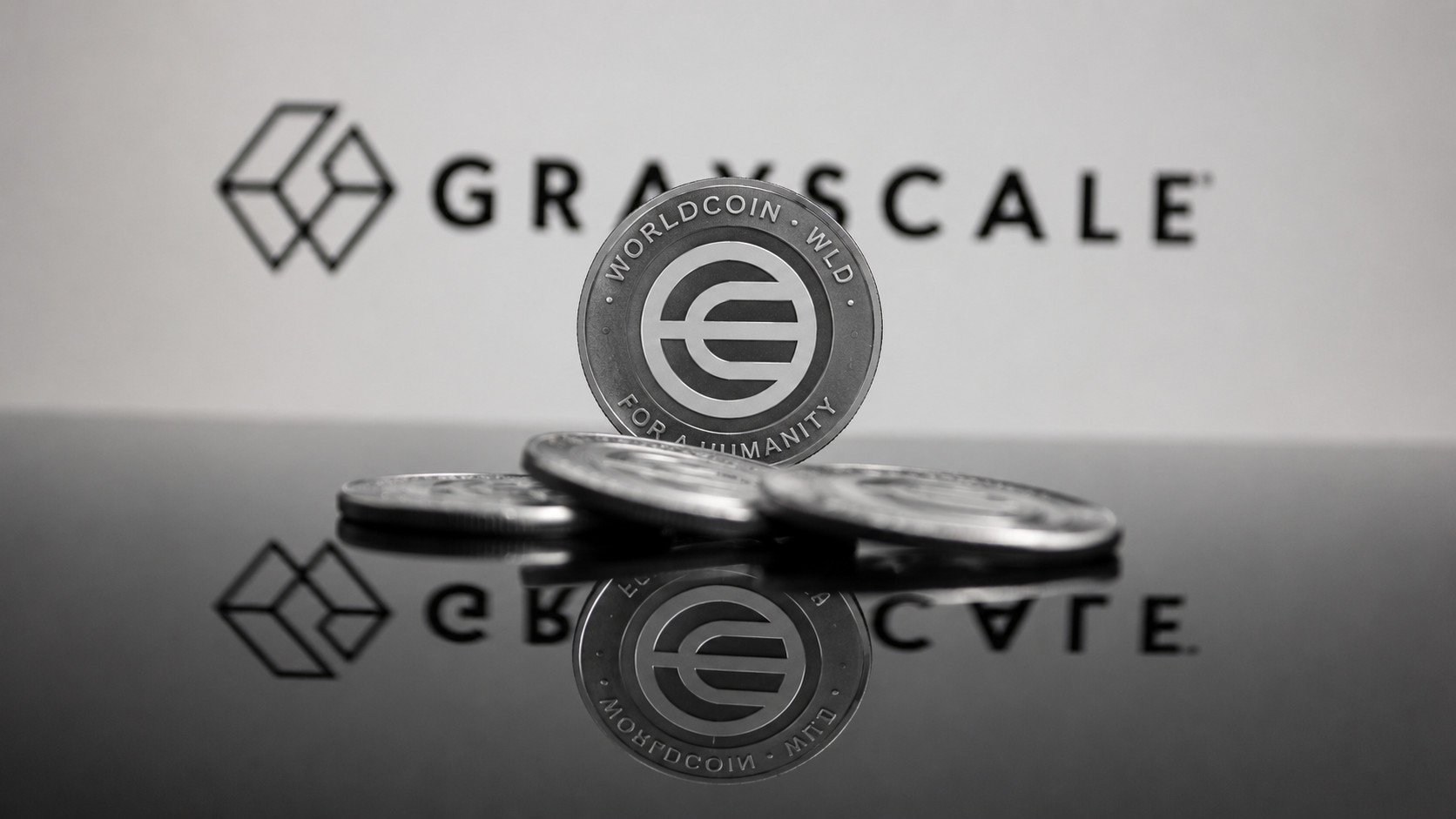 Ein Worldcoin steht vor dem Logo von Grayscale